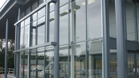 Grey aluminium curtain walling on a commercial building, seen from outside in flat daylight